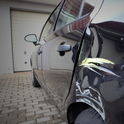 Schwarzes Fahrzeug mit eingedellter Seitenwand